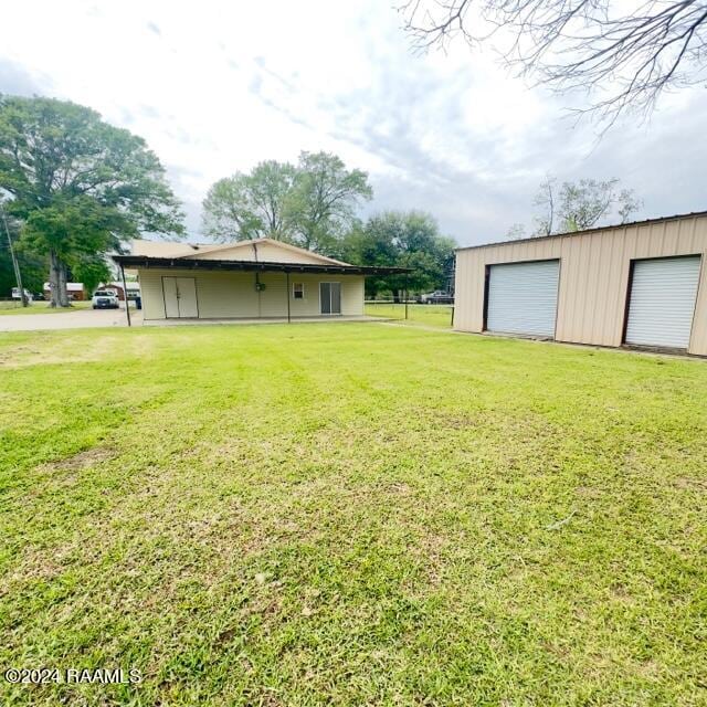 view of yard featuring a garage and an outdoor structure