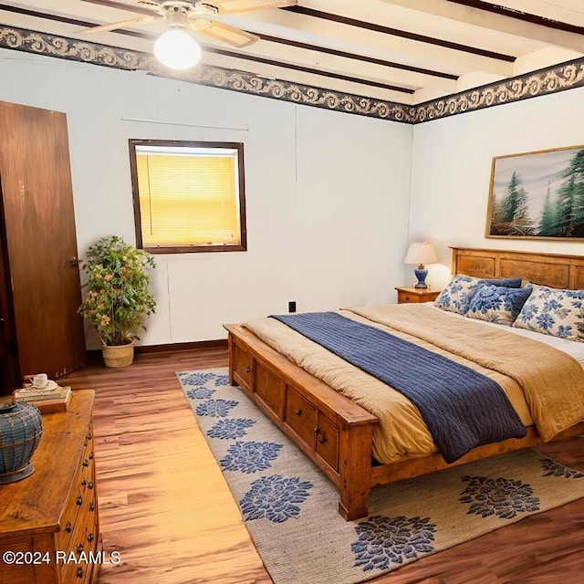 bedroom featuring ceiling fan, beam ceiling, and wood-type flooring