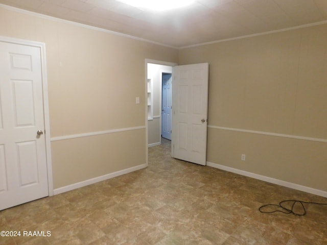 spare room with light tile floors and crown molding