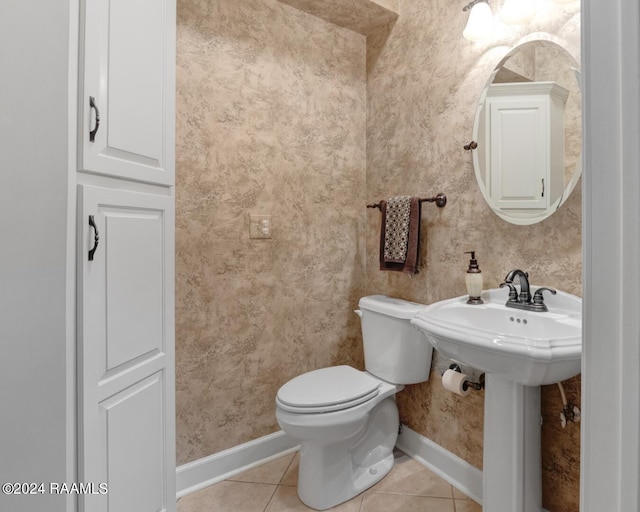 bathroom with toilet, tile floors, and sink