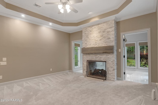 unfurnished living room with plenty of natural light, a tray ceiling, ceiling fan, and a fireplace