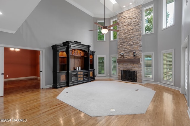 living room featuring a high ceiling, ceiling fan, a healthy amount of sunlight, and a fireplace