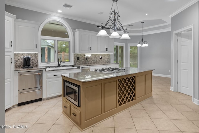 kitchen featuring white cabinets, a center island, light stone countertops, and appliances with stainless steel finishes