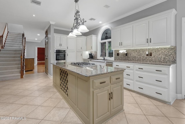 kitchen featuring a kitchen island, hanging light fixtures, backsplash, stainless steel appliances, and light stone countertops