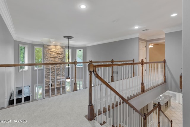 hallway featuring crown molding, light colored carpet, and a healthy amount of sunlight