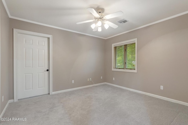 carpeted empty room with crown molding and ceiling fan