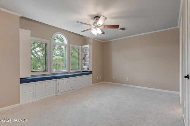 carpeted empty room featuring ornamental molding and ceiling fan