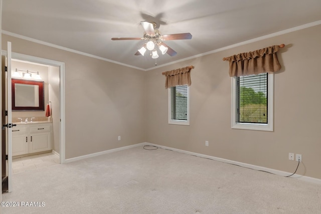 carpeted spare room with ornamental molding, ceiling fan, and sink