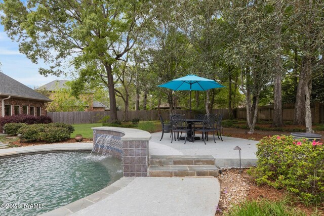 view of pool with a patio area and pool water feature