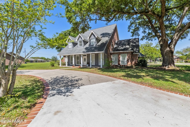 cape cod house featuring a front yard and covered porch