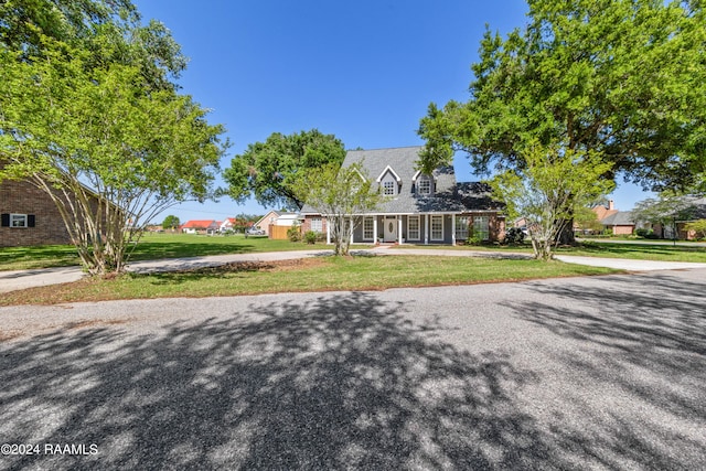 cape cod-style house with a front lawn