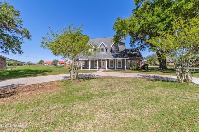 cape cod-style house featuring a front lawn and covered porch