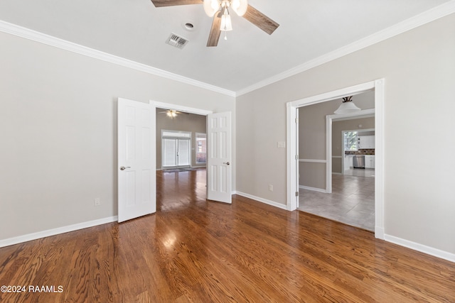 unfurnished room with hardwood / wood-style floors, ceiling fan, and crown molding