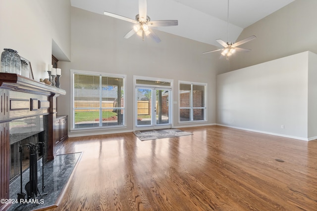 living room with hardwood / wood-style floors, high vaulted ceiling, ceiling fan, and a premium fireplace