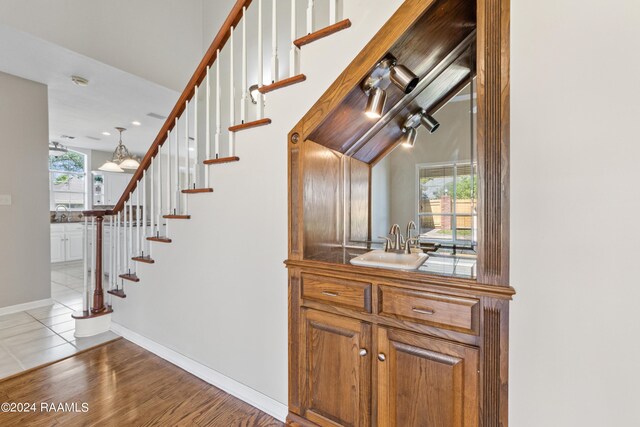 stairway with hardwood / wood-style floors and sink