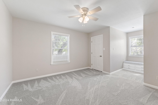 spare room with ceiling fan and light colored carpet