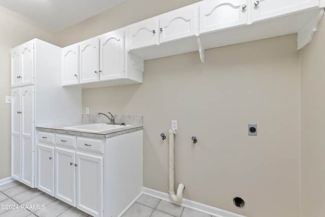 washroom with hookup for an electric dryer, light tile patterned floors, cabinets, and sink