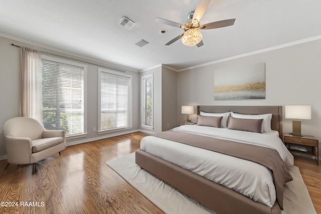 bedroom featuring ceiling fan, crown molding, and light hardwood / wood-style flooring