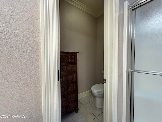 bathroom featuring toilet, ornamental molding, and tile flooring