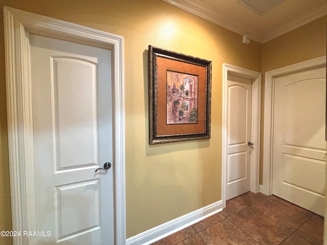 corridor featuring ornamental molding and dark tile floors