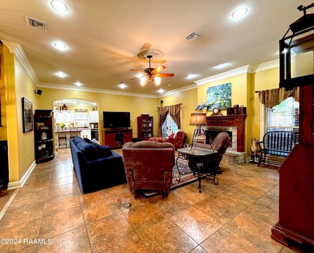 living room featuring light tile floors, ceiling fan, and crown molding