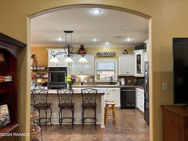 kitchen with decorative light fixtures, white cabinetry, crown molding, black appliances, and backsplash