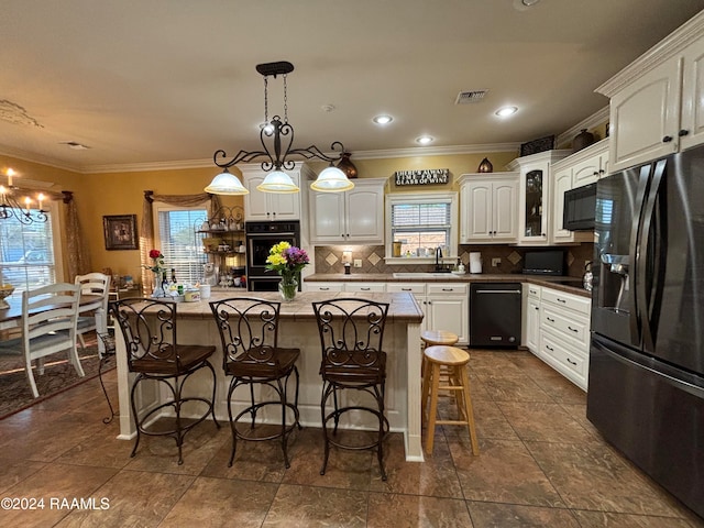 kitchen featuring a notable chandelier, backsplash, black appliances, and a healthy amount of sunlight