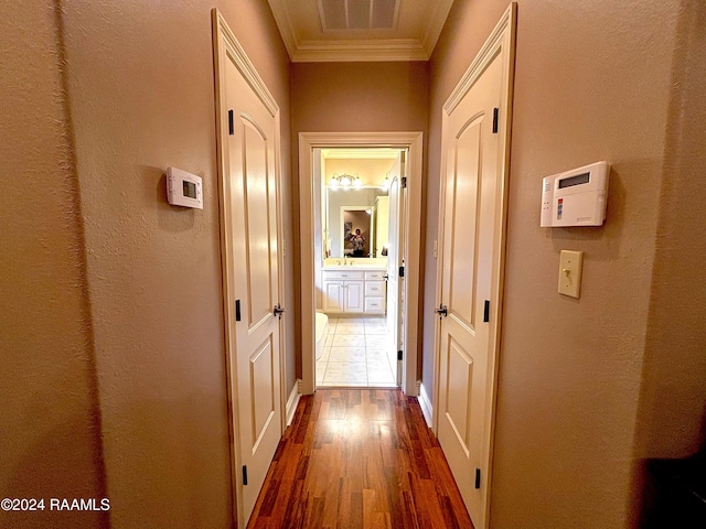 hallway with dark tile flooring and ornamental molding