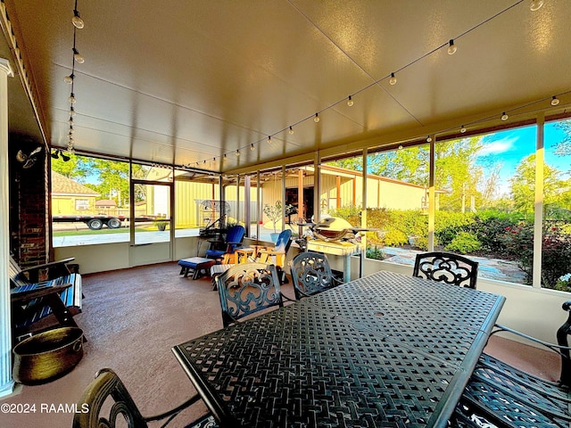 sunroom with plenty of natural light and rail lighting