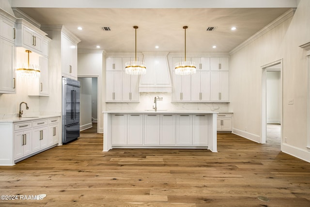 kitchen featuring hardwood / wood-style floors, hanging light fixtures, white cabinetry, and stainless steel built in refrigerator