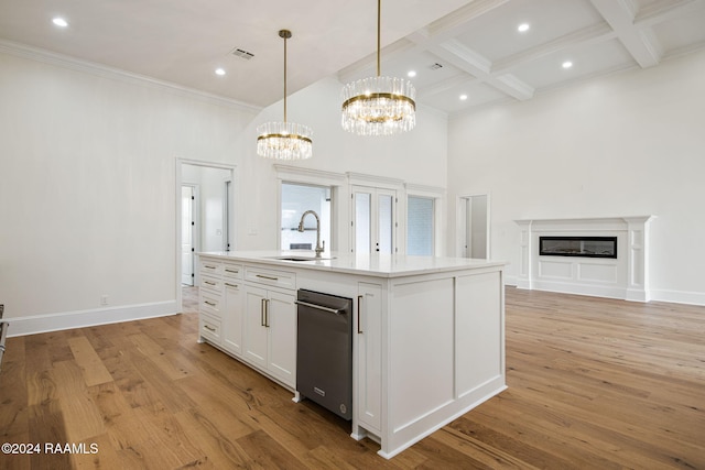 kitchen featuring light hardwood / wood-style floors, white cabinets, hanging light fixtures, sink, and a kitchen island with sink