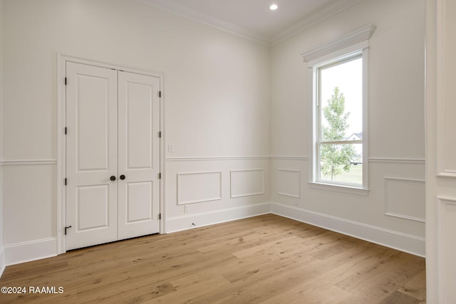 unfurnished room with light hardwood / wood-style floors, plenty of natural light, and crown molding