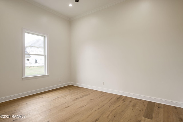 empty room featuring light hardwood / wood-style floors and crown molding