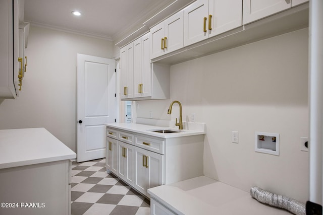 laundry area featuring cabinets, sink, washer hookup, electric dryer hookup, and crown molding