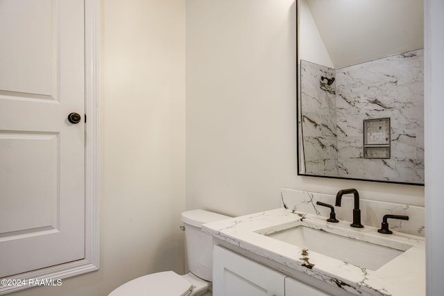 bathroom featuring vanity, toilet, and lofted ceiling