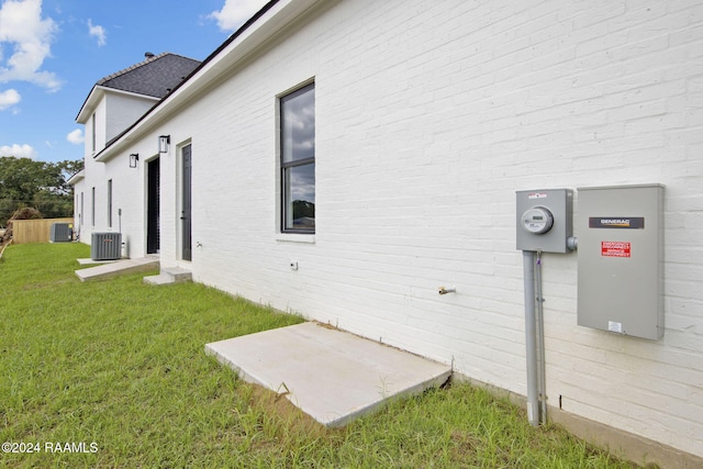 view of side of home featuring central AC and a yard