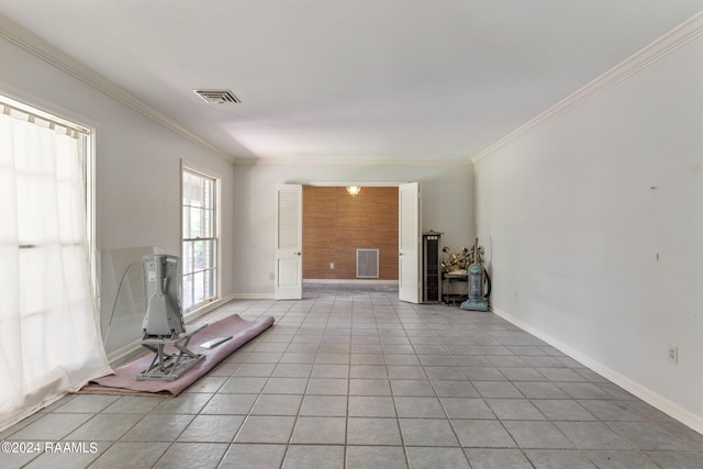 unfurnished living room with crown molding and light tile floors