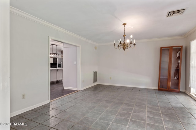 empty room with dark tile flooring, a chandelier, and ornamental molding