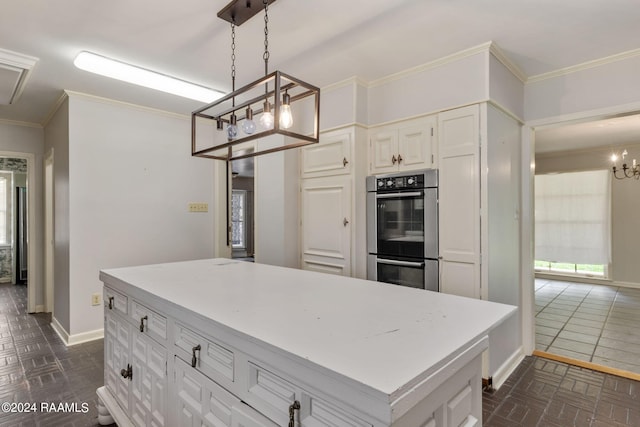 kitchen with a center island, double oven, white cabinetry, hanging light fixtures, and crown molding