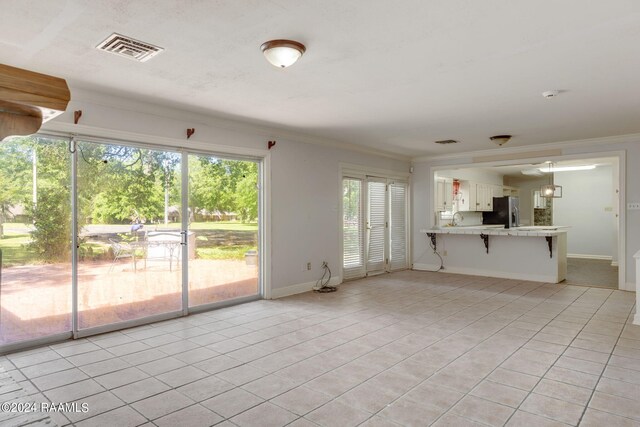 unfurnished living room with sink and light tile floors