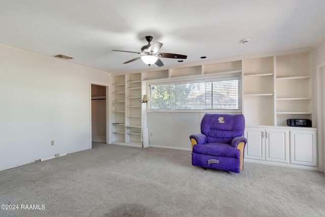 unfurnished room with built in shelves, ornamental molding, light carpet, and ceiling fan