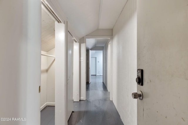 hall featuring dark wood-type flooring and vaulted ceiling