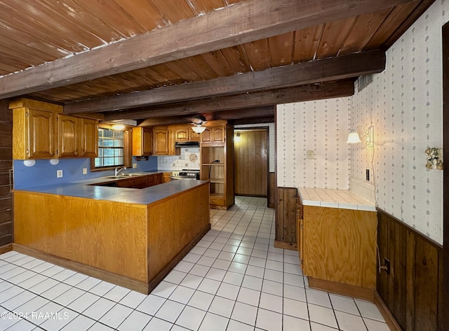 kitchen with beamed ceiling, light tile flooring, wooden ceiling, kitchen peninsula, and sink