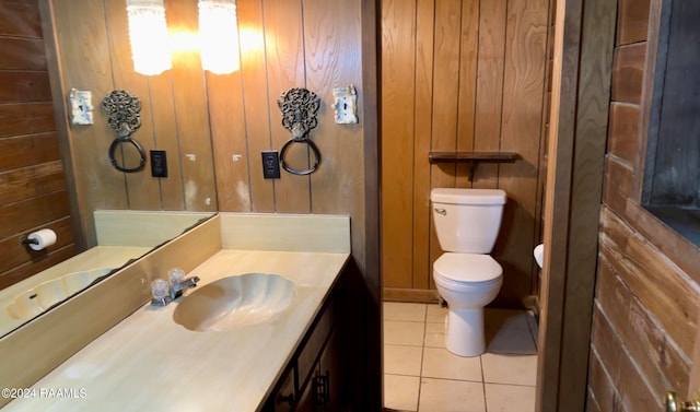 bathroom with wood walls, toilet, and vanity