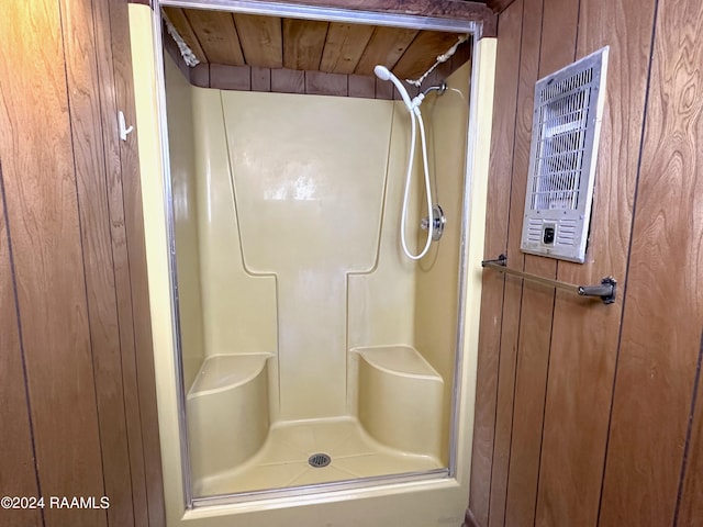 bathroom with wood walls, a shower with shower door, and wood ceiling