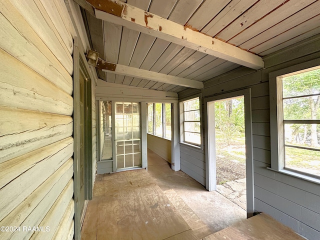 unfurnished sunroom with a wealth of natural light, wood ceiling, and vaulted ceiling with beams