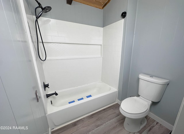 bathroom featuring tiled shower / bath combo, toilet, and hardwood / wood-style flooring