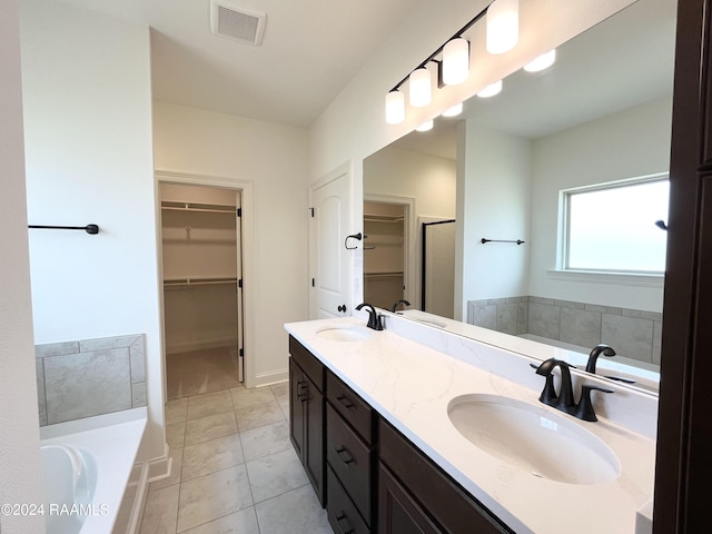 bathroom featuring tile patterned flooring, vanity, and a washtub