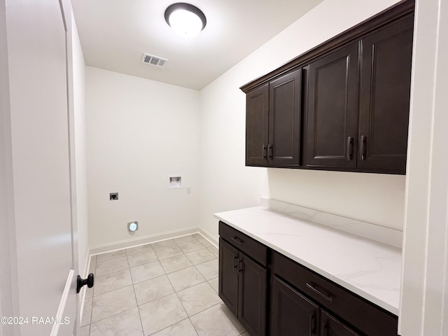 washroom with cabinets, washer hookup, light tile patterned floors, and electric dryer hookup