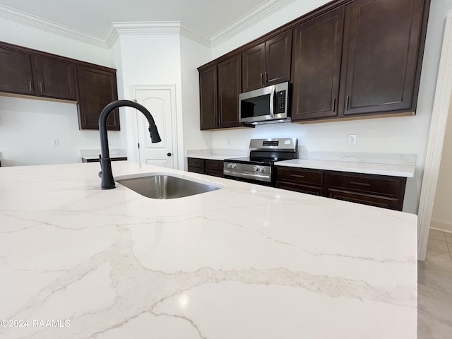 kitchen featuring appliances with stainless steel finishes, light stone counters, ornamental molding, dark brown cabinets, and sink